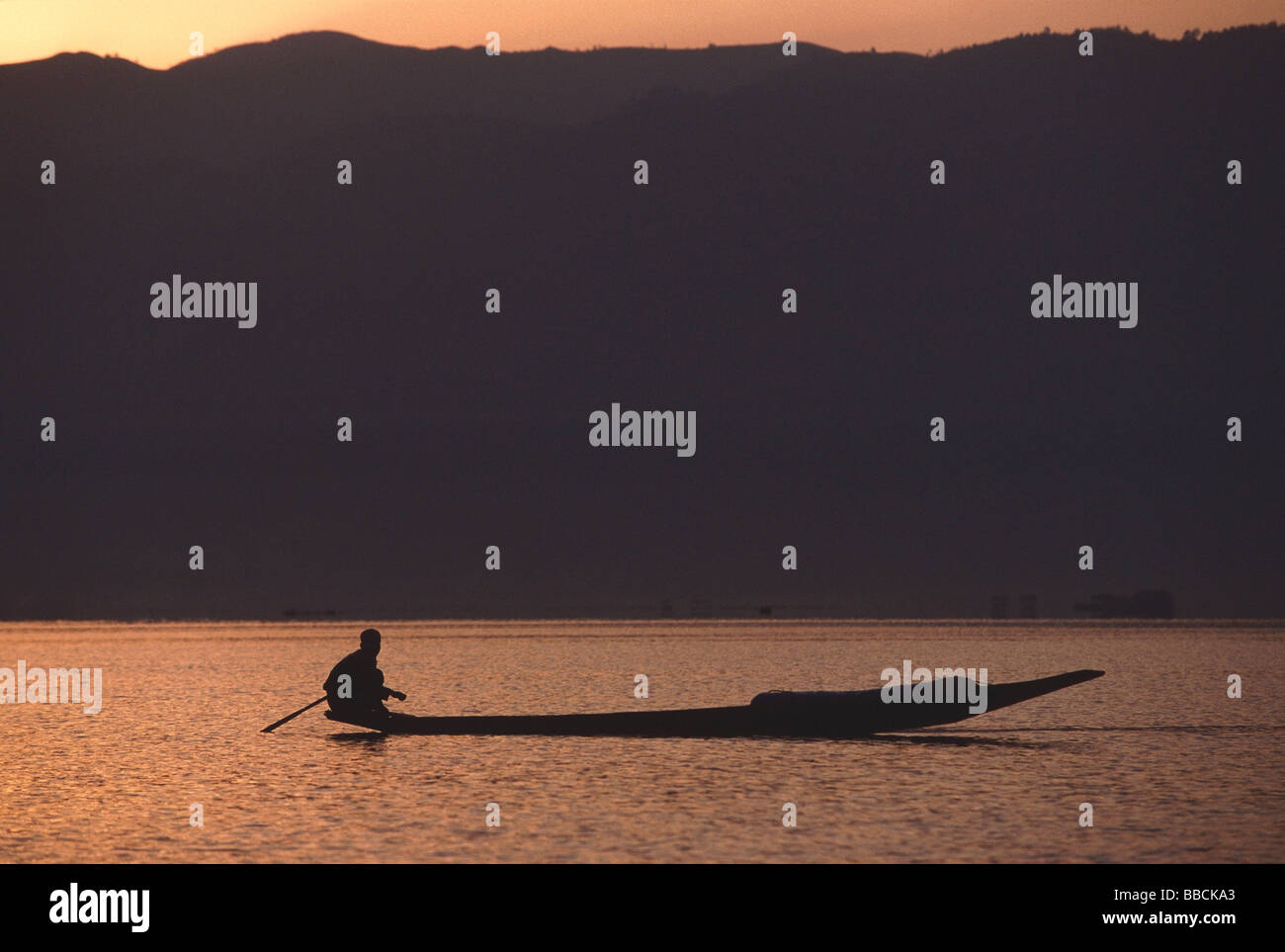 Myanmar (Burma), Inle lake, Silhouette of fisherman in canoe at sunrise ...