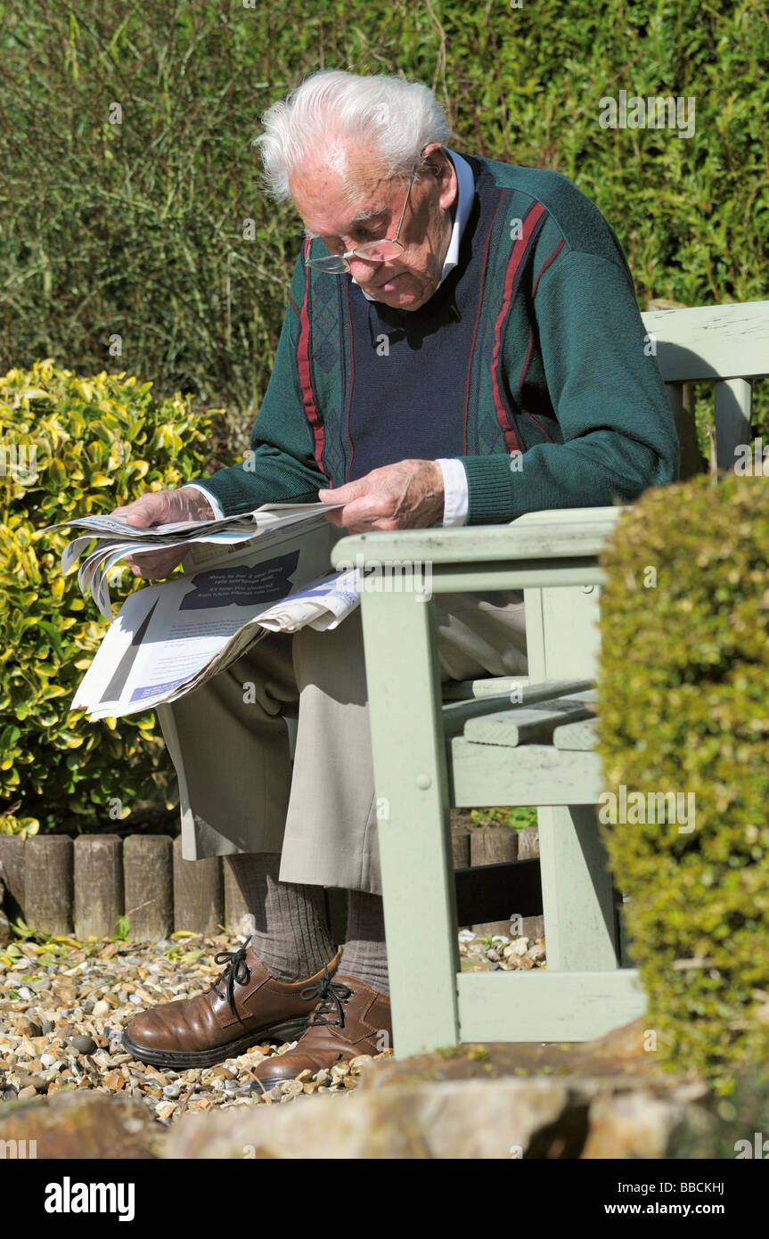 Elderly gentleman reading a newspaper in the garden Stock Photo Alamy