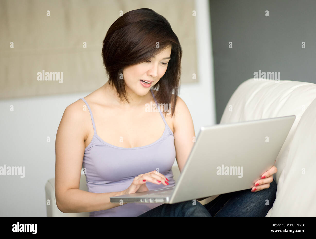 Young female using laptop in her home Stock Photo