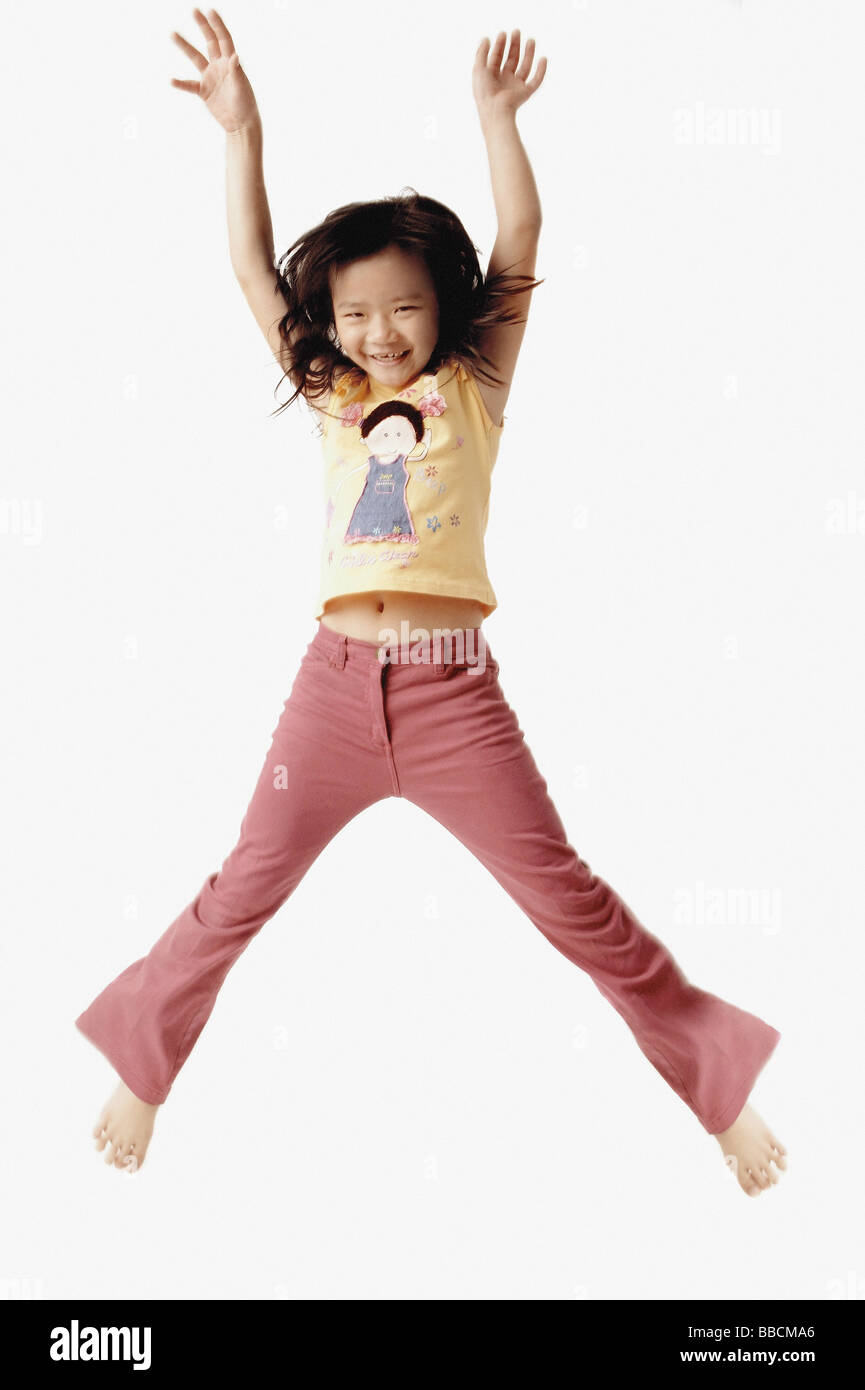Girl jumping in the air with outstretched arms. Stock Photo