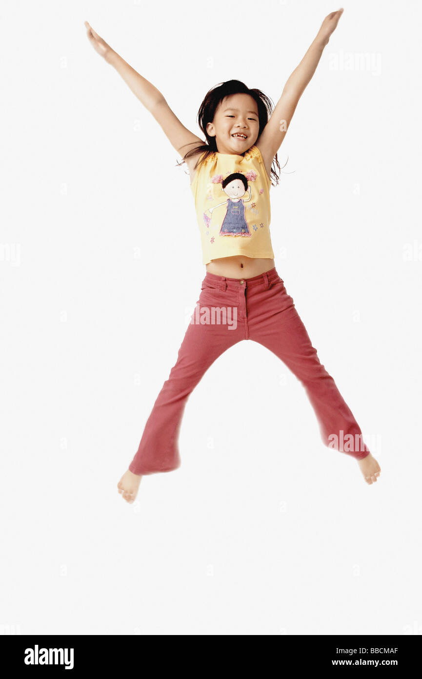Girl jumping in the air with outstretched arms. Stock Photo