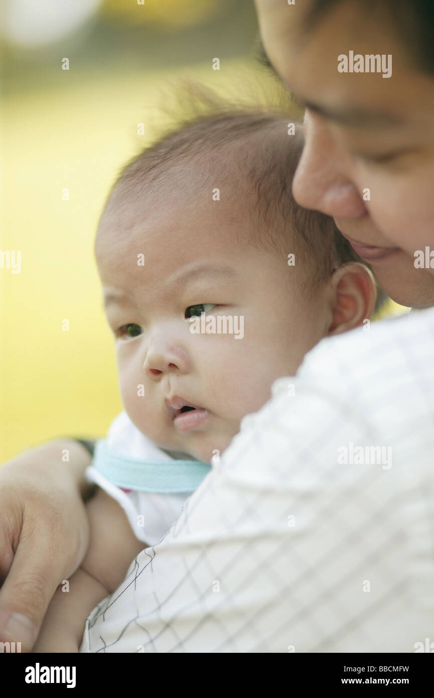 Father carrying baby, over the shoulder view Stock Photo Alamy