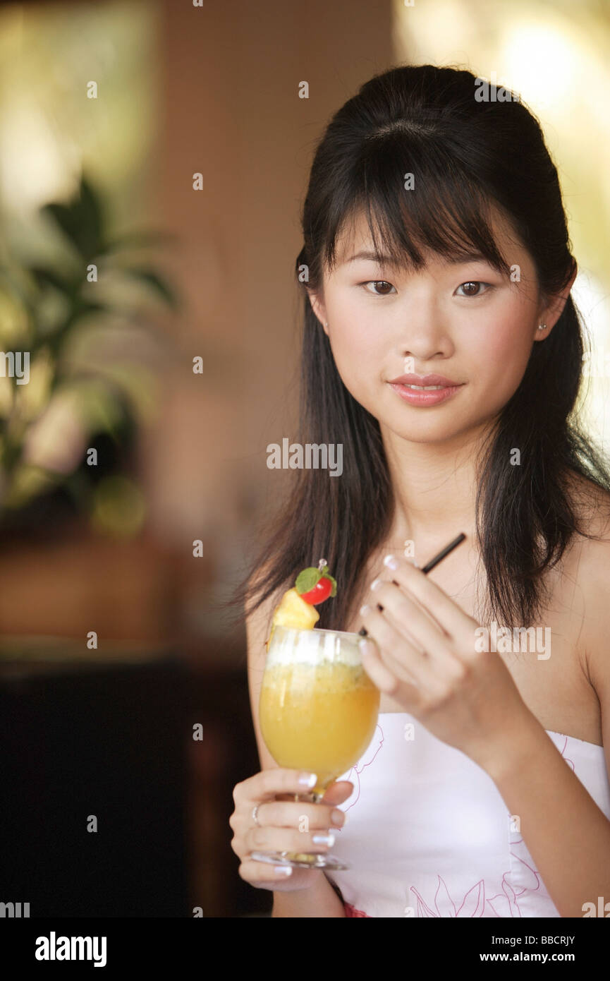 Young woman holding a drink, looking at camera Stock Photo - Alamy