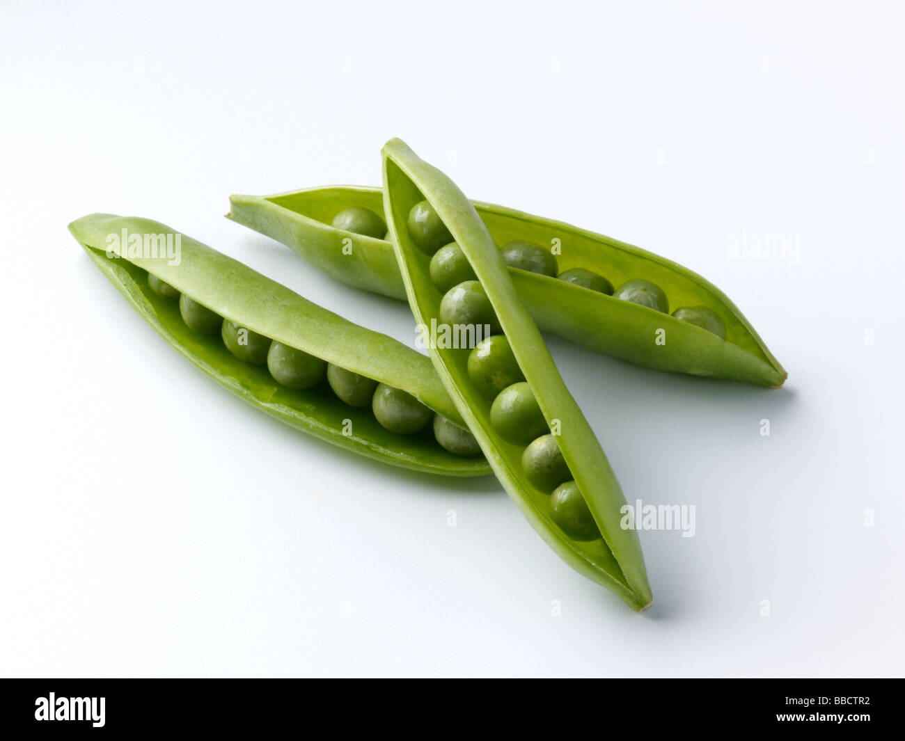 Peas in pods on a white background Stock Photo - Alamy