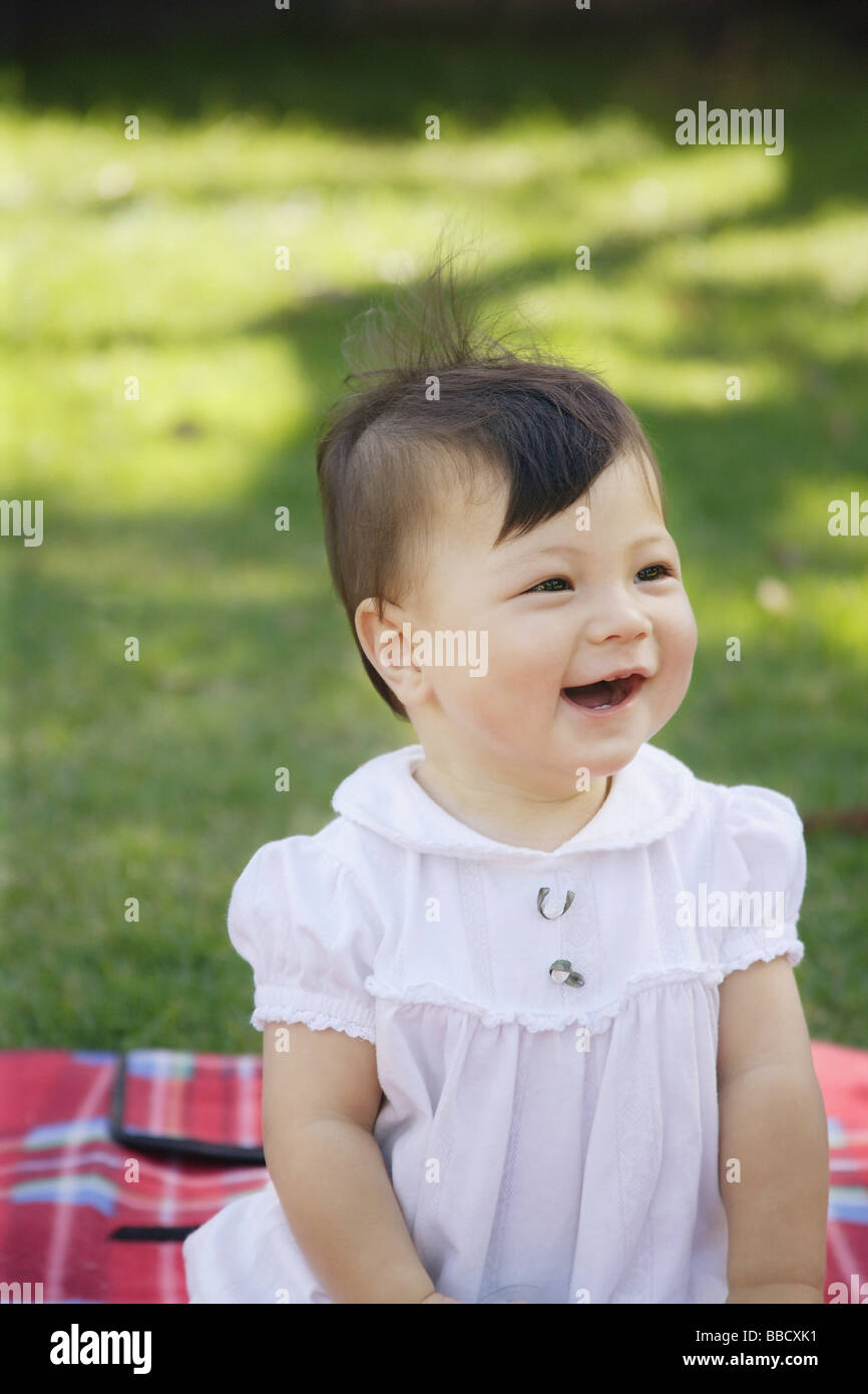 Baby girl on picnic blanket, looking away, portrait Stock Photo Alamy
