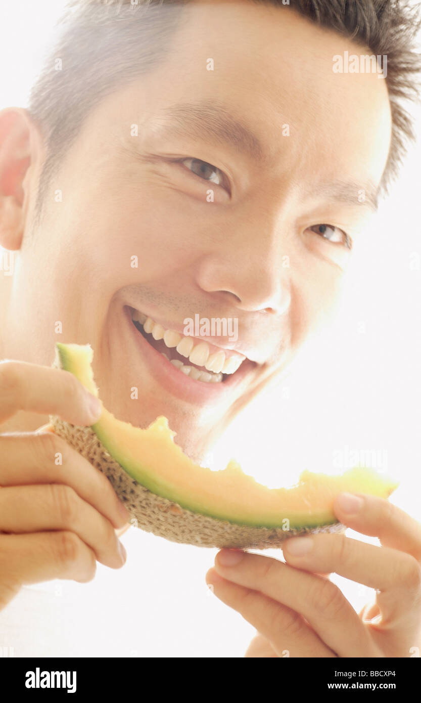 Man holding melon slice, smiling Stock Photo Alamy
