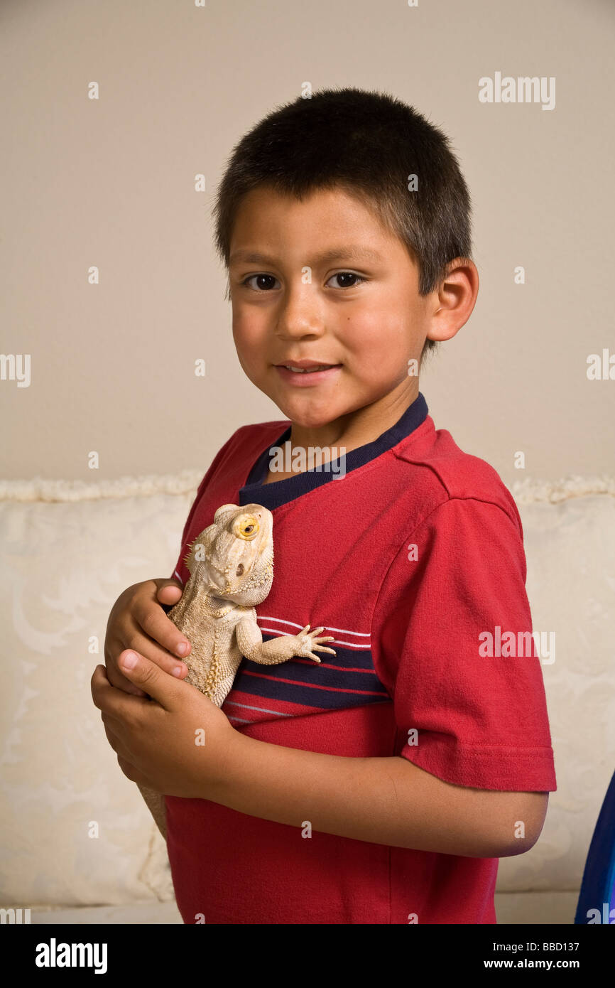 Adopted Hispanic boy 6-7 years oldholds pet he adopted from animal rescue cutout closeup white background MR  © Myrleen Pearson Stock Photo