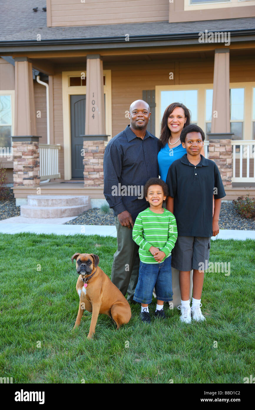 Family and dog in front of home Stock Photo