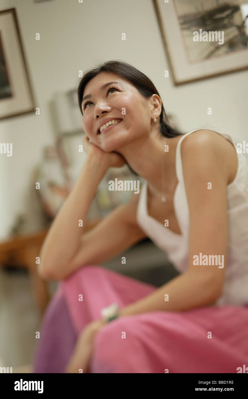 Woman with hand on chin, looking up Stock Photo - Alamy