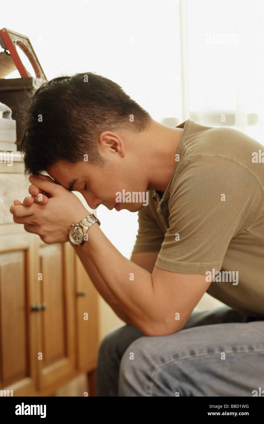 Man sitting, head in hands Stock Photo Alamy