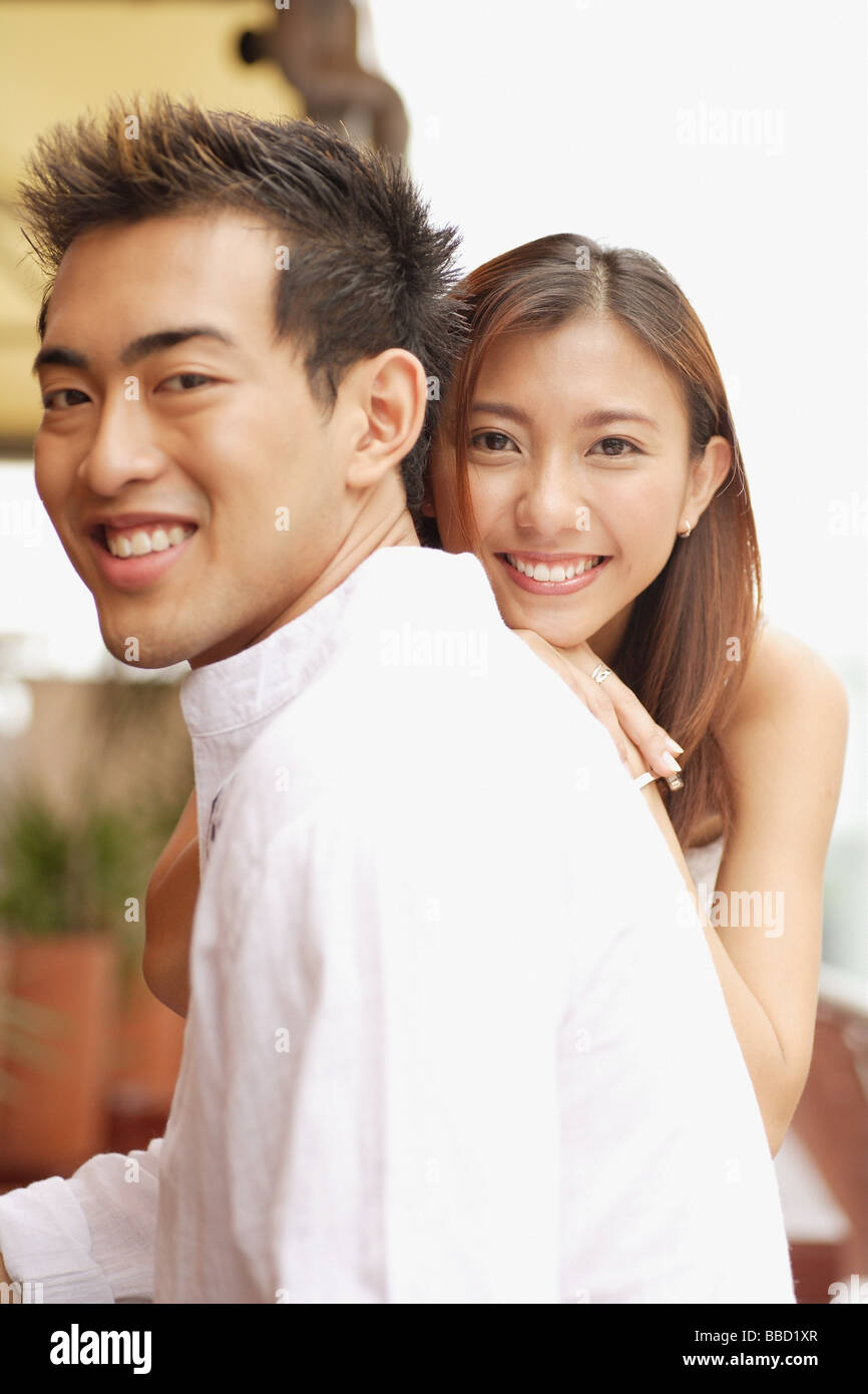 Young man in profile, young woman in front of him, smiling Stock Photo