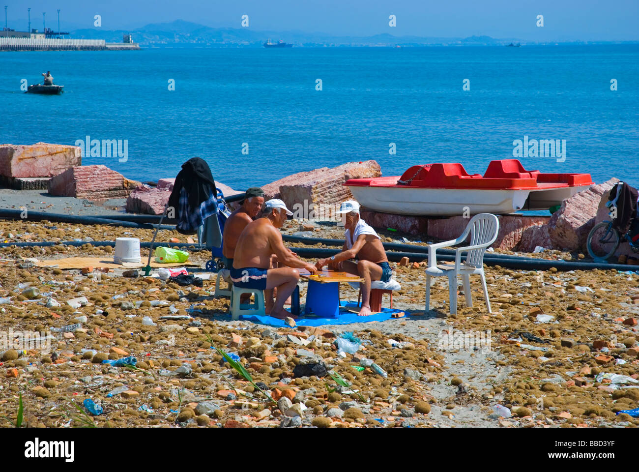 People playing a boardgame on a dirty beach in Durres Albania Europe