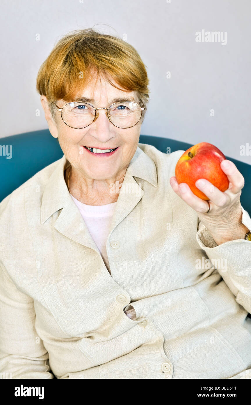 Elderly woman eating healthy holding a nutritious apple Stock Photo Alamy