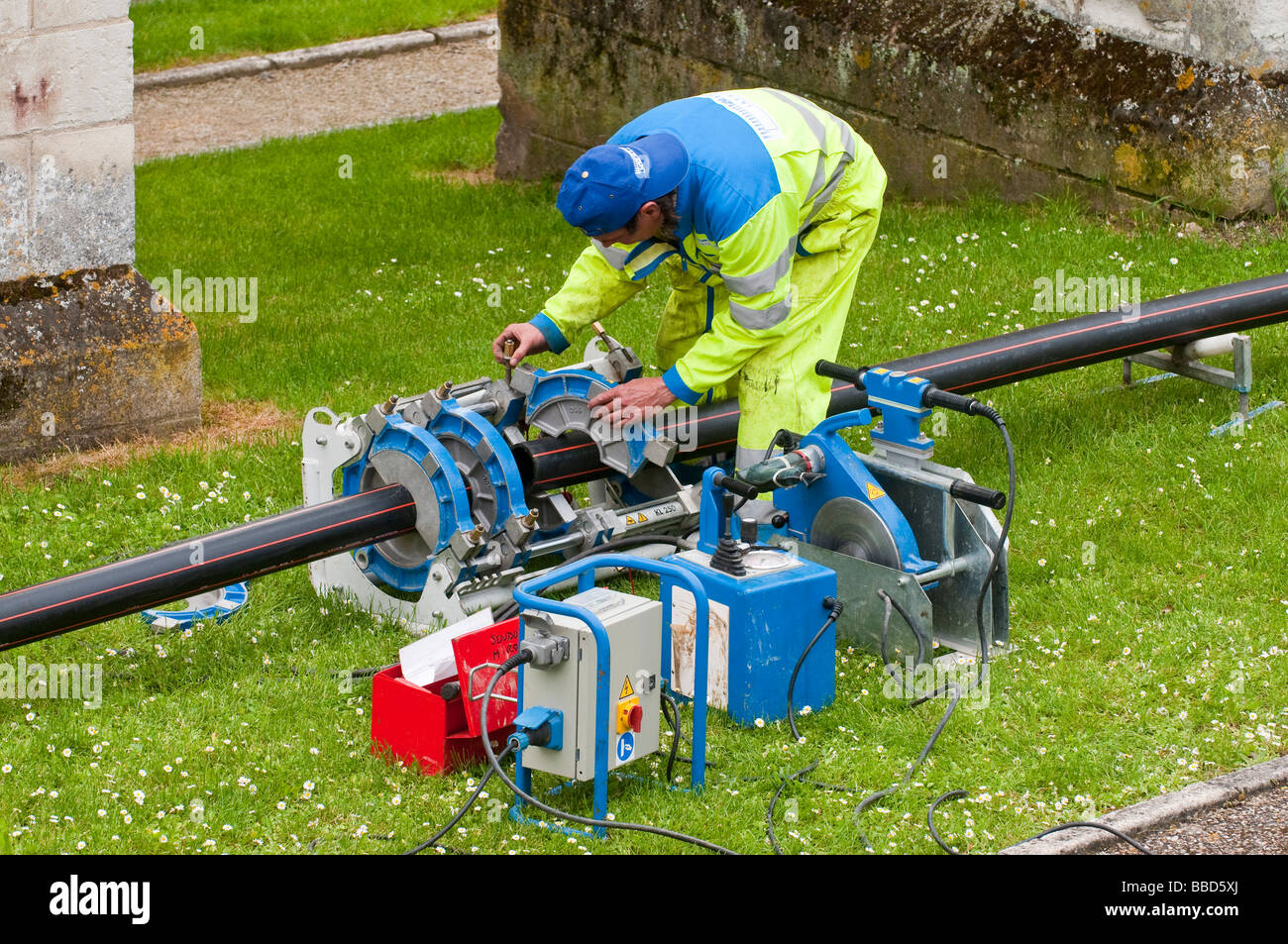 Contractor operating heat-weld flexible conduit machine - France. Stock Photo
