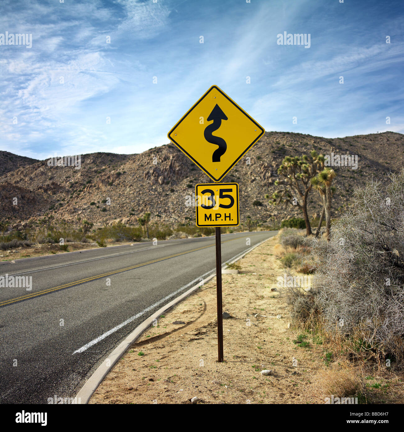 Yellow safety road sign by desert highway Stock Photo