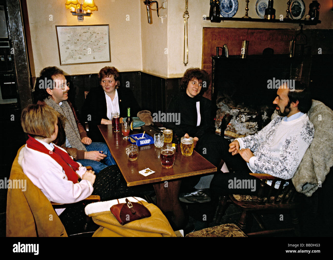 Group of friends sitting in pub and enjoying a drink and a chat, England, 1980s. Stock Photo