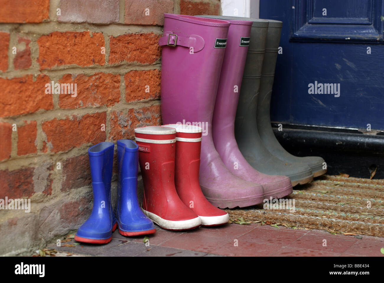 Four Pairs of Wellington Boots on a Doorstep Stock Photo