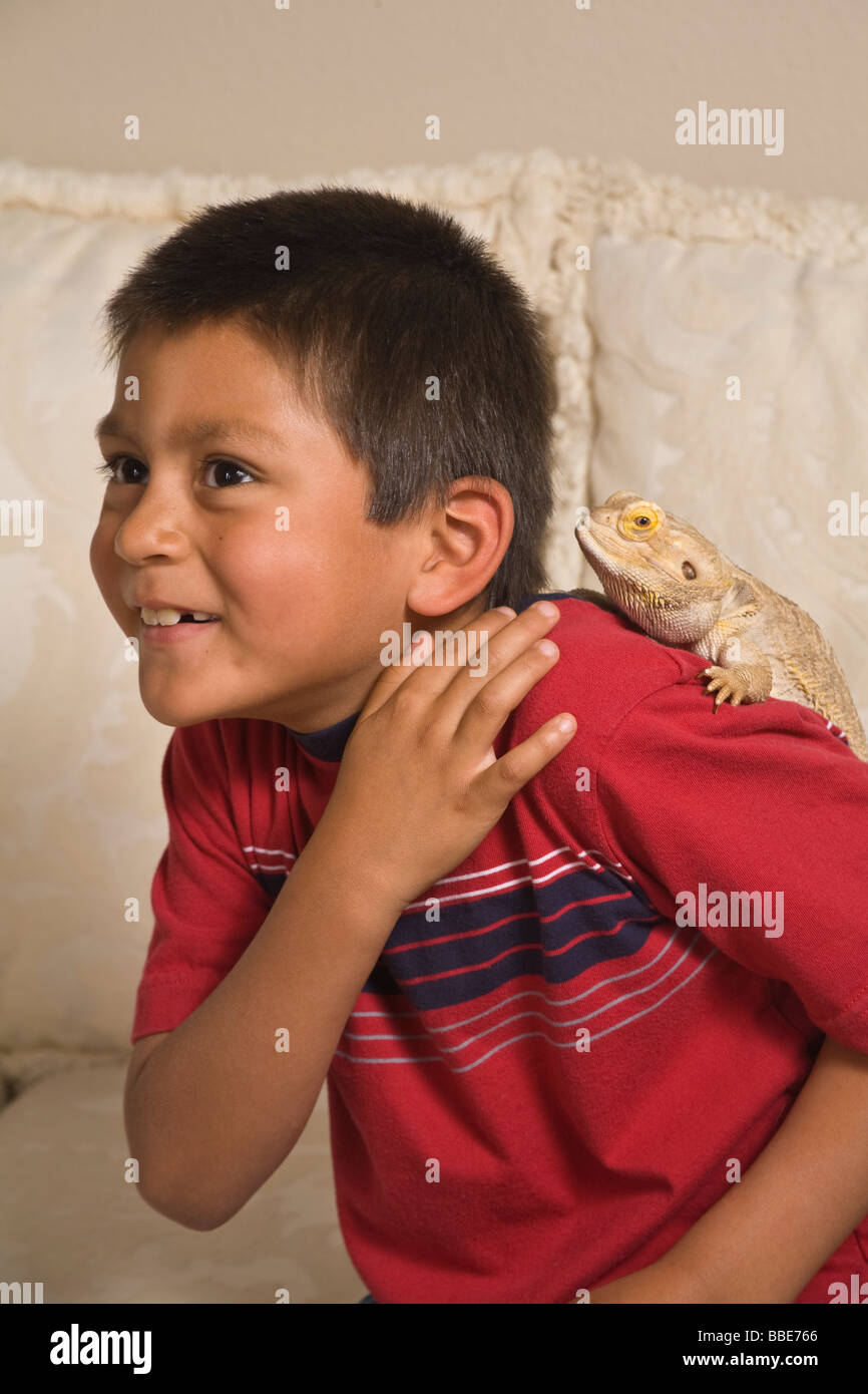 Portrait Hispanic boy 7-9 year olds age laughing Bearded Dragon on shoulder fun funny humorous cute  MR    © Myrleen Pearson Stock Photo