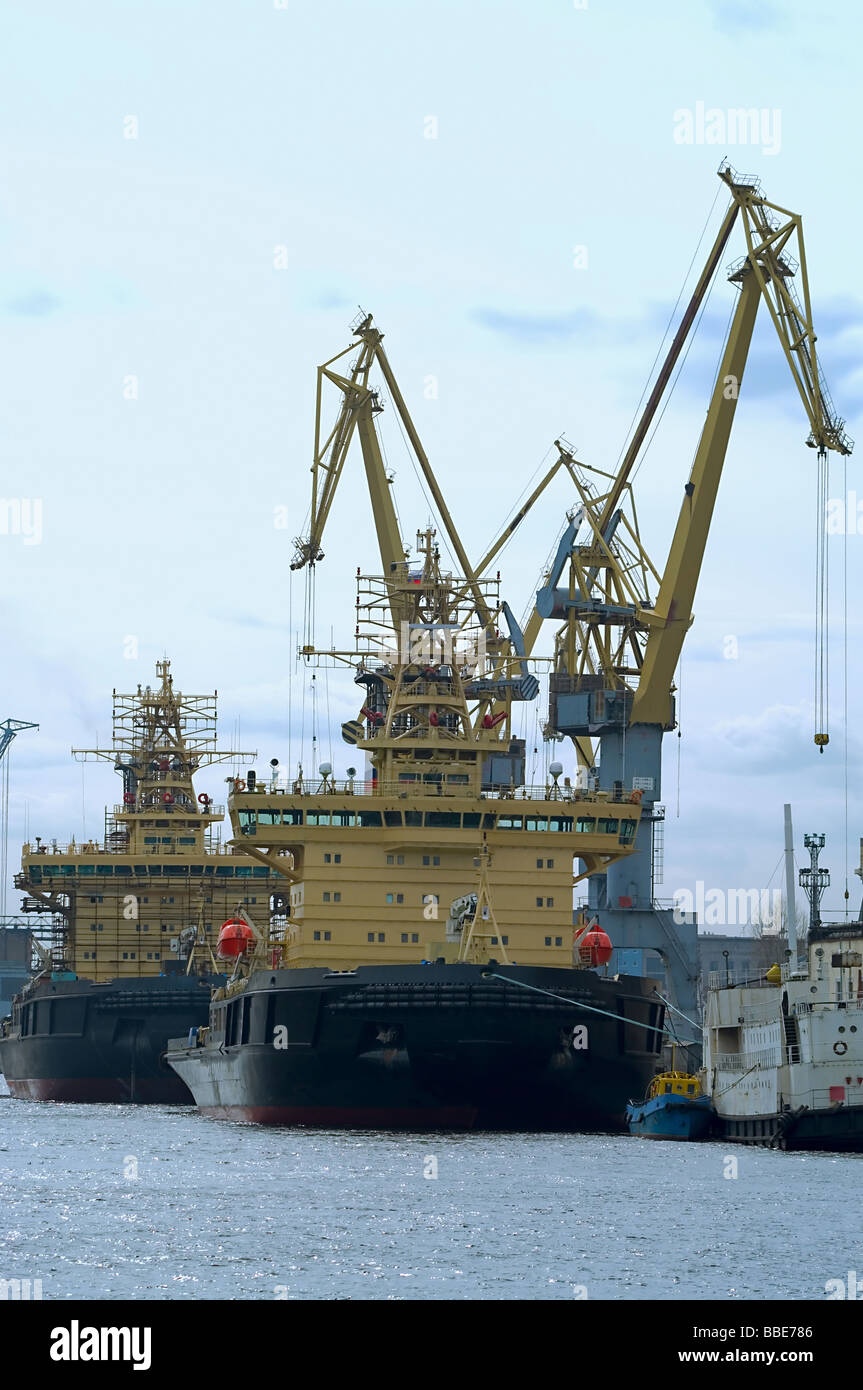 Several ships load cargo on board by harbor cranes in port of shipment