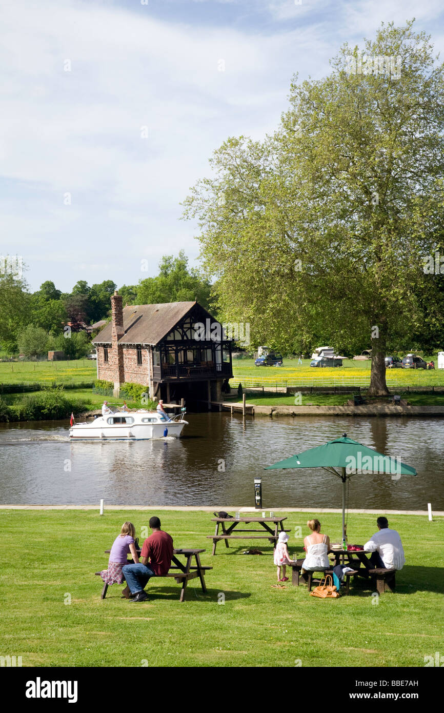 People enjoying a sunny day on the banks of the river Thames at Shillingford, Oxfordshire, UK Stock Photo