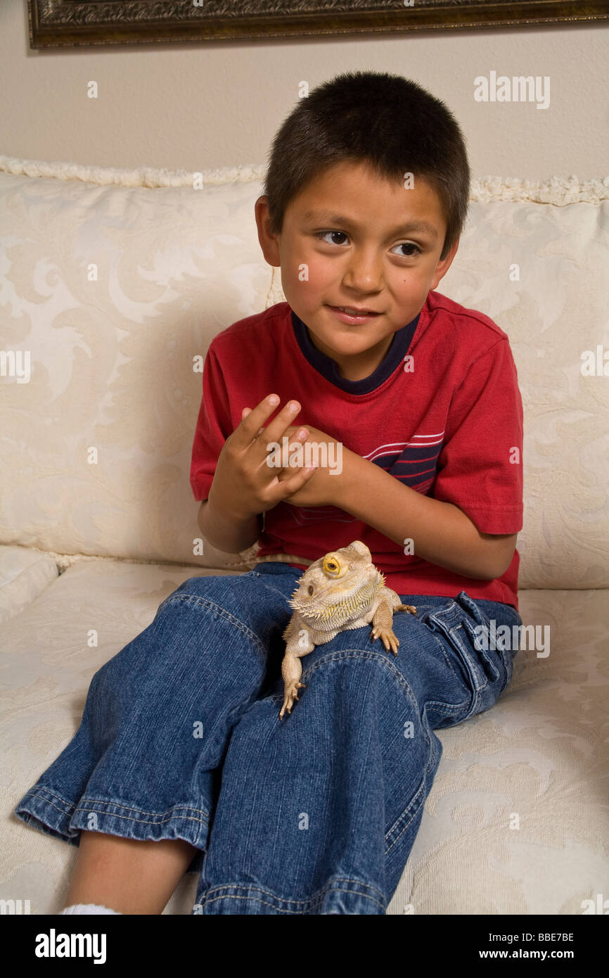 Portrait of young Hispanic boy sitting on couch with Bearded Dragon strange creature creatures doubtful unsure frightened  MR  © Myrleen Pearson Stock Photo