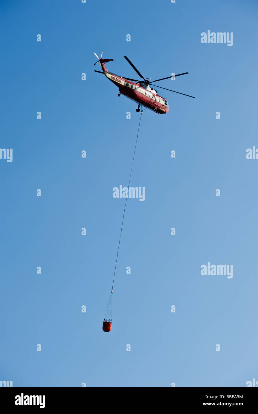 Water dropping fire fighting Helicopter flies through air Stock Photo ...