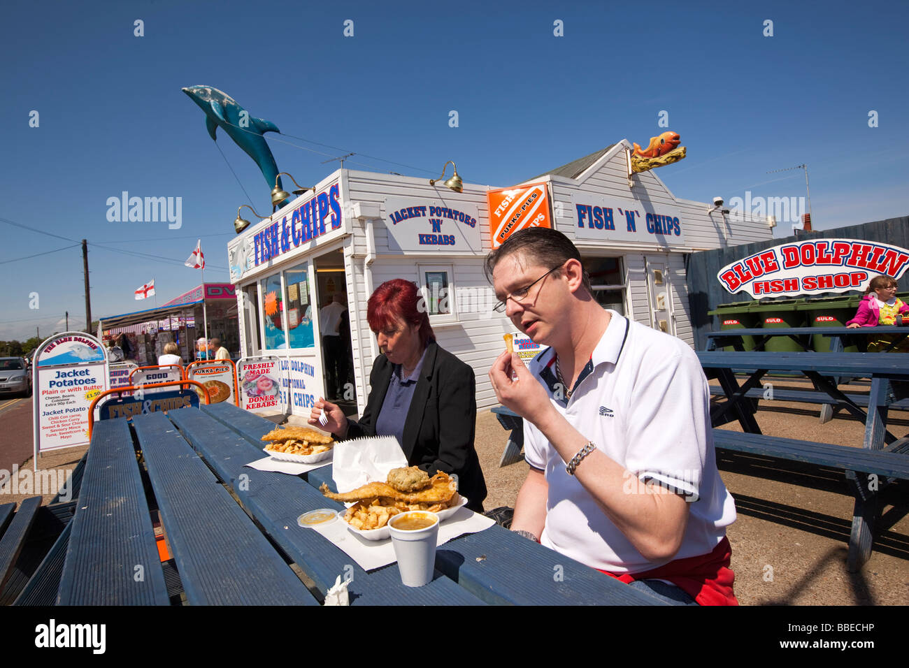 UK England Norfolk Hemsby Beach Road two people eating fish and chips
