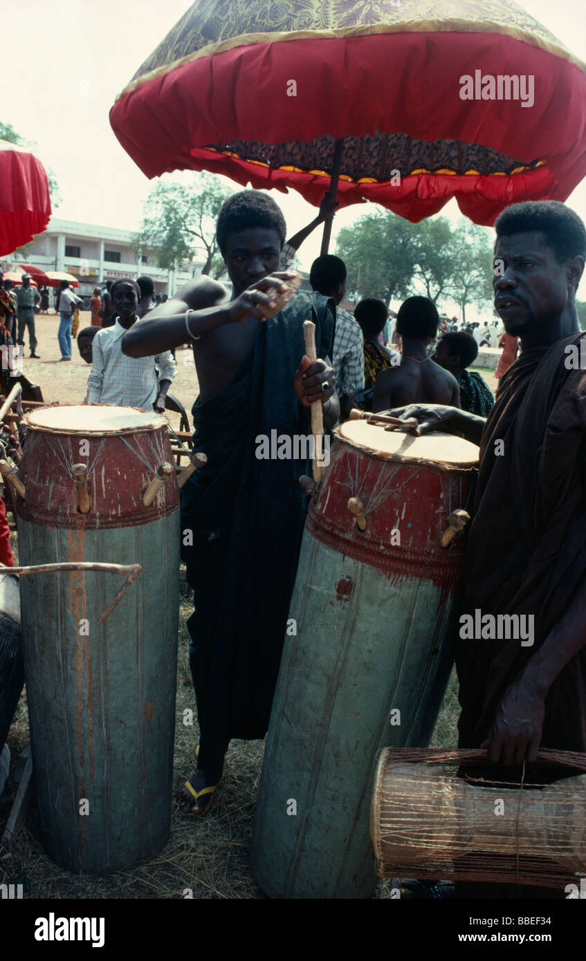GHANA West Africa Traditional drummers tuning drums under umbrella