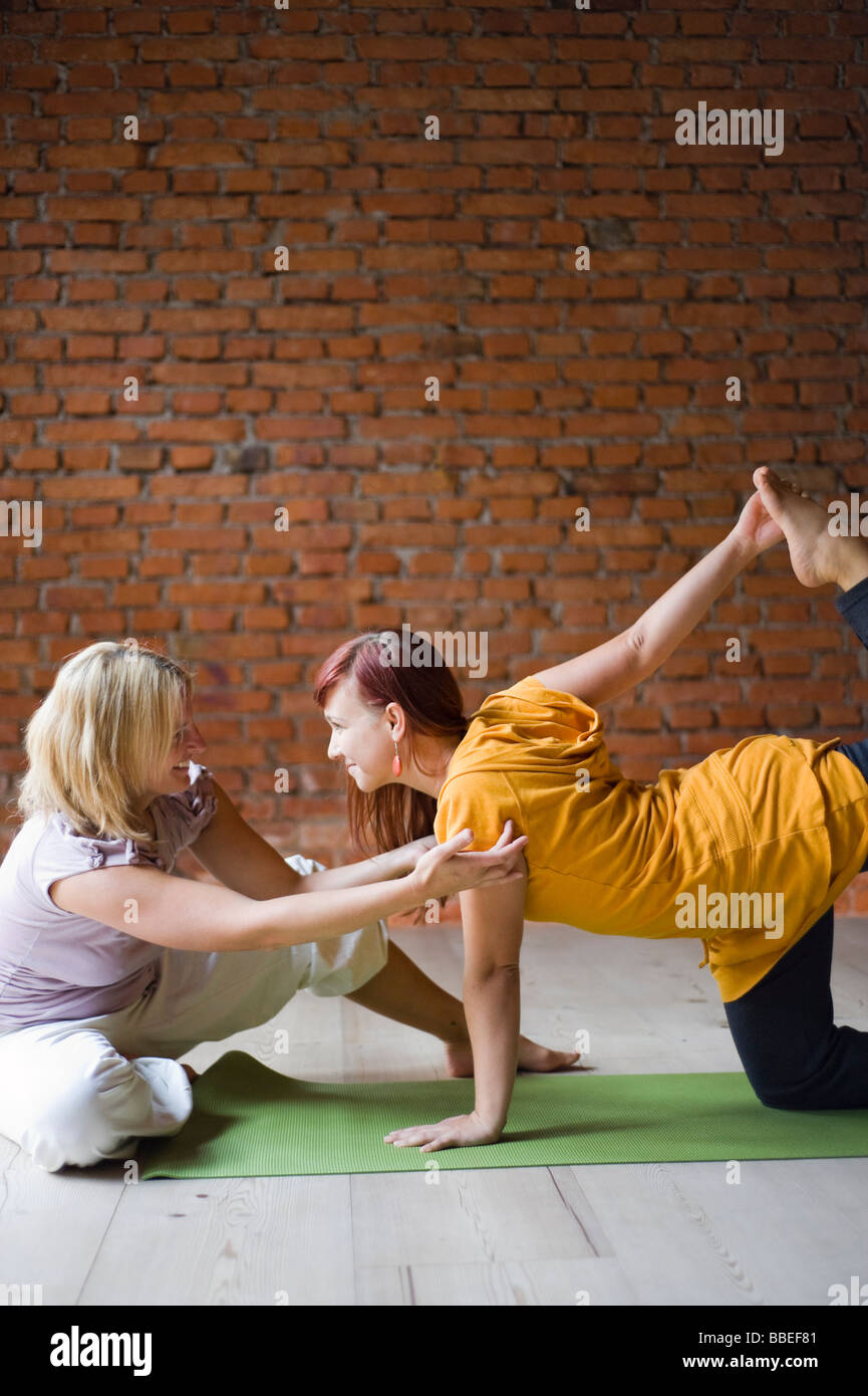 Yoga Teacher With Student, Doing Tiger Pose Stock Photo