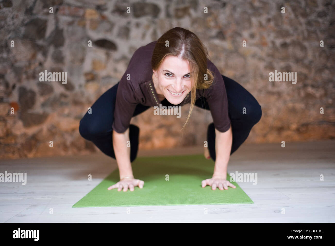 Woman in Yoga Class Doing Crow Pose Stock Photo