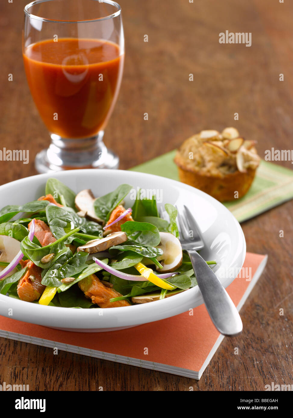 Spinach Salad With Salmon and Mushrooms, Almond Muffin, and Glass of Tomato Juice Stock Photo