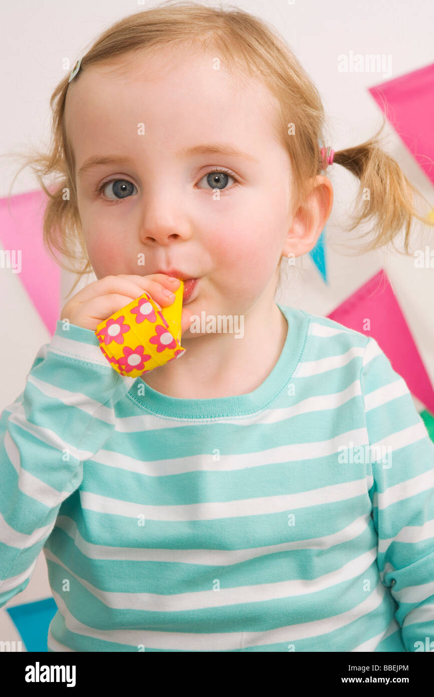 Little Girl Blowing a Noisemaker at a Birthday Party Stock Photo Alamy