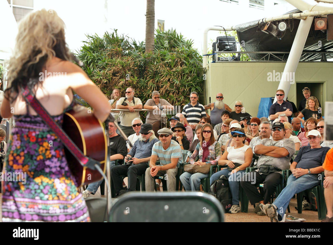 Female blues playing guitar and singing to crowd focus on crowd Stock Photo