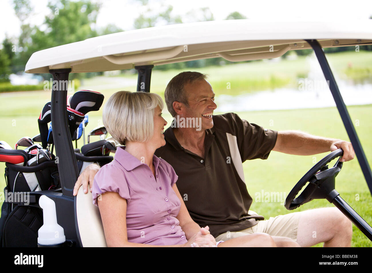 Couple Driving Golf Cart, Burlington, Ontario, Canada Stock Photo