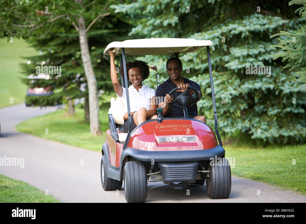 Couple Riding in Golf Cart Stock Photo