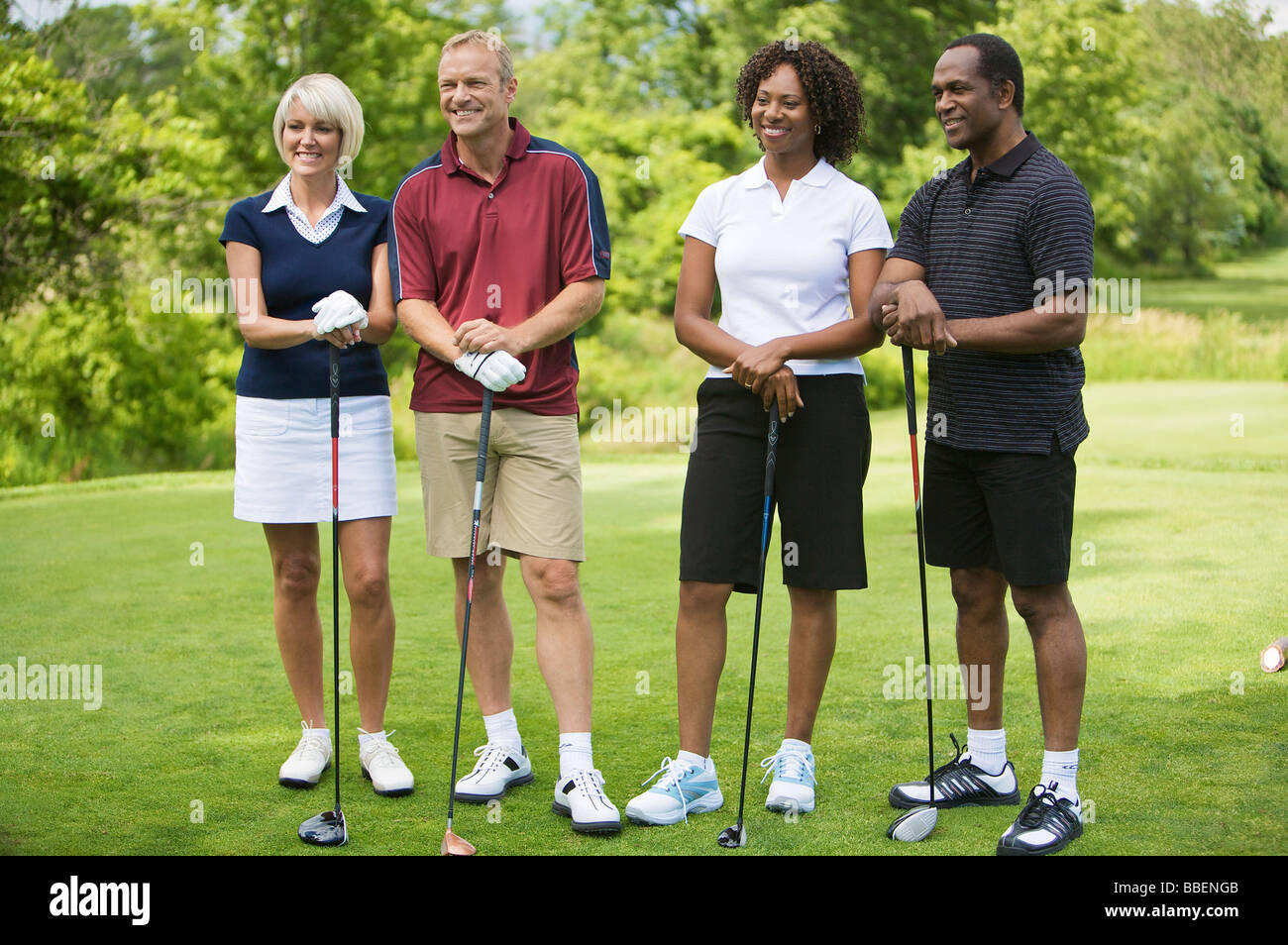 Portrait of Couples Standing and Leaning on Golf Clubs Stock Photo