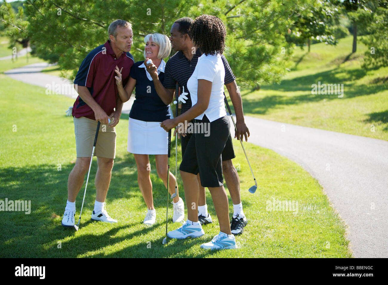 Couples Chatting on Golf Course Stock Photo