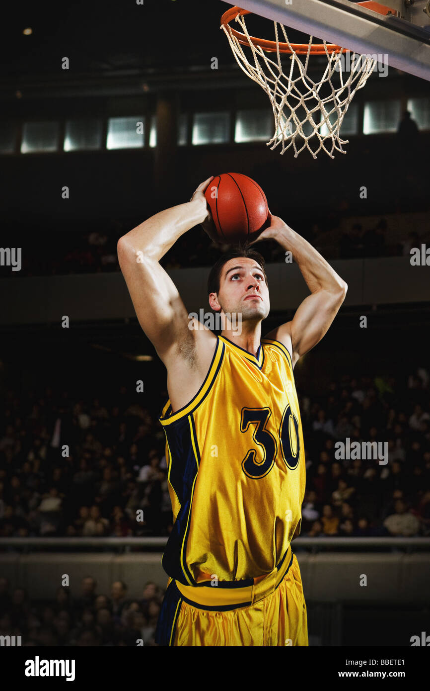 Young man holding basketball over his head Stock Photo