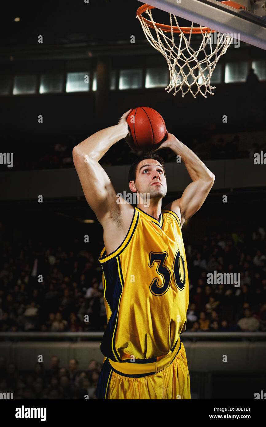 Young man holding basketball over his head Stock Photo - Alamy