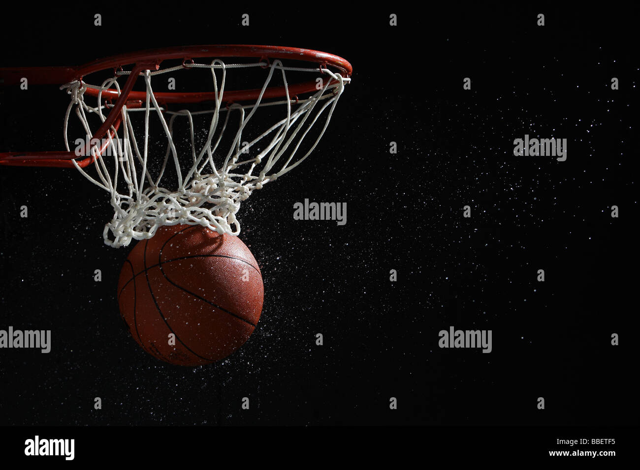 Basketball going through hoop Stock Photo