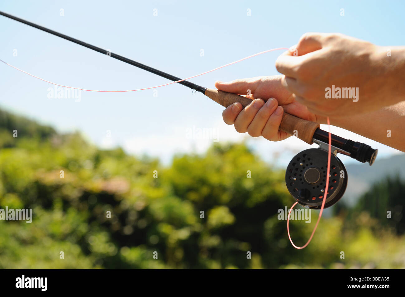 Hands holding fishing rod and reel Stock Photo Alamy