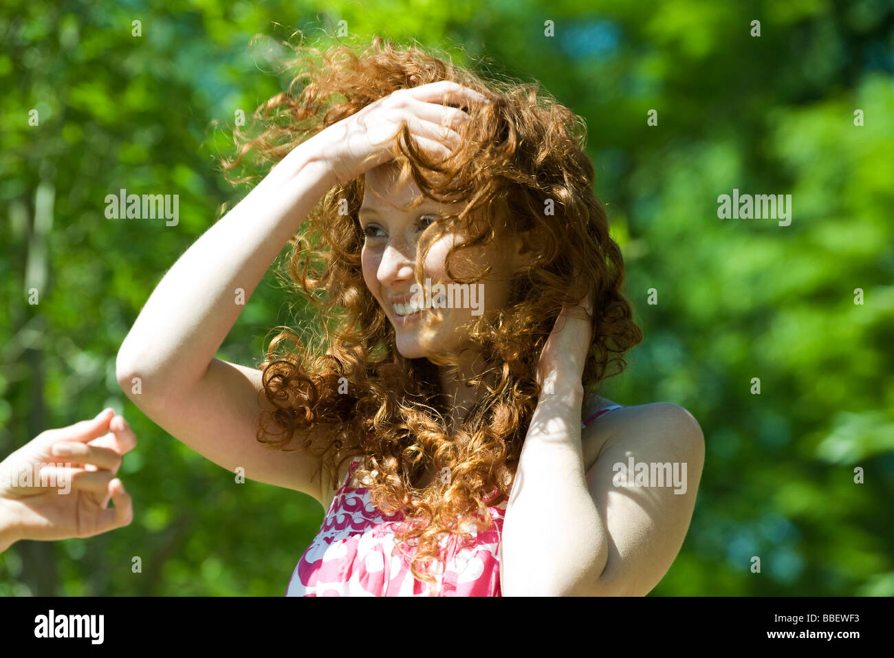 Young woman with red hair outdoors on windy day Stock Photo