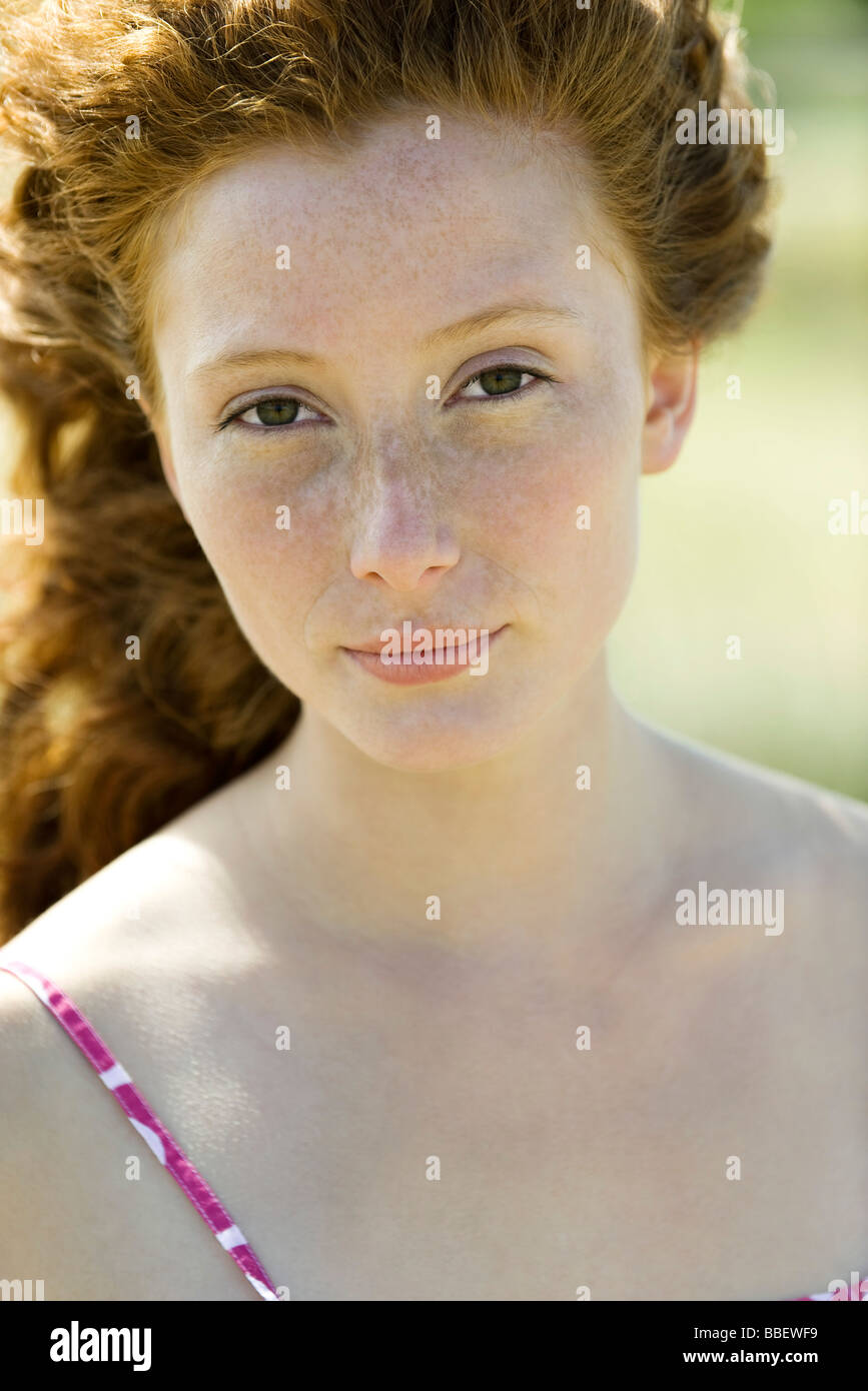 Young red haired woman looking at camera, portrait Stock Photo