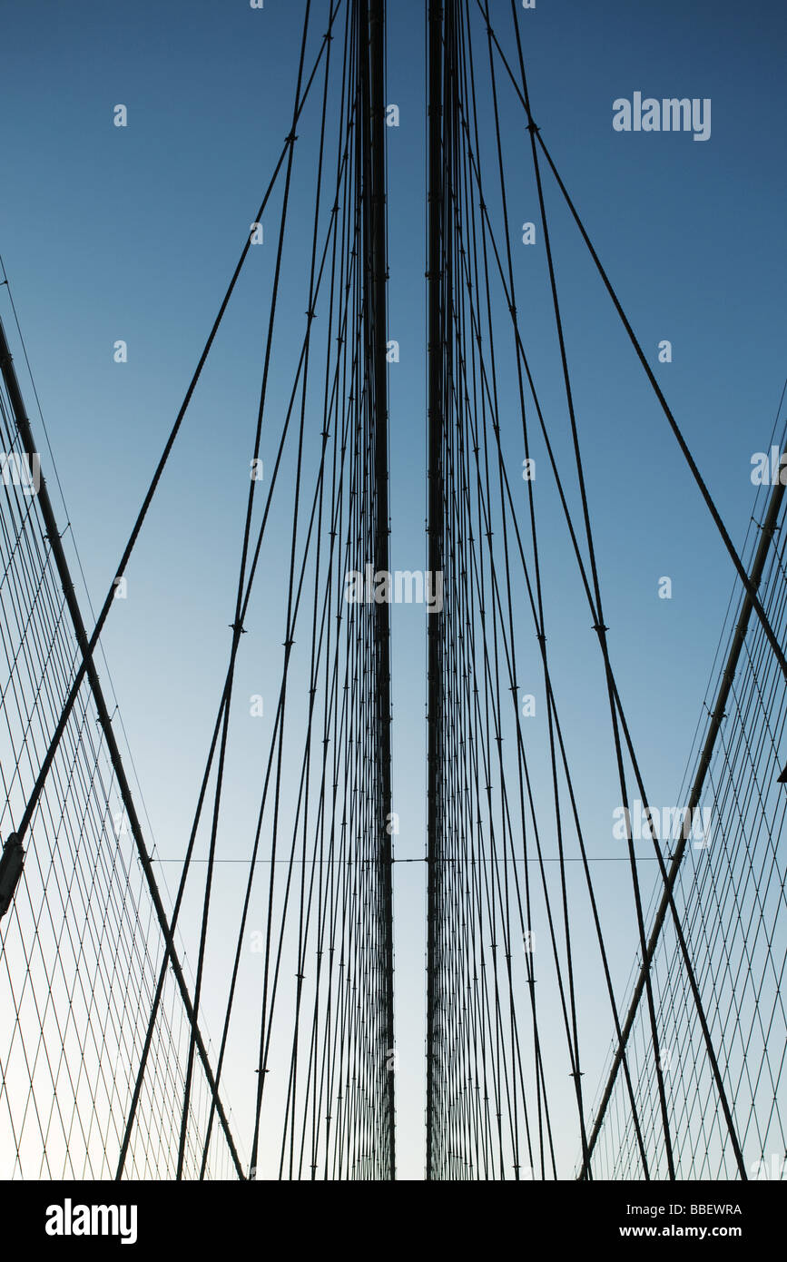 Iron support wires of suspension bridge against blue sky, low angle view Stock Photo