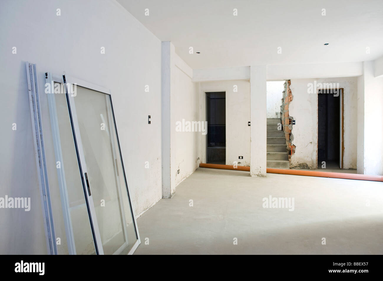 Interior of apartment under renovation, windows leaning against wall