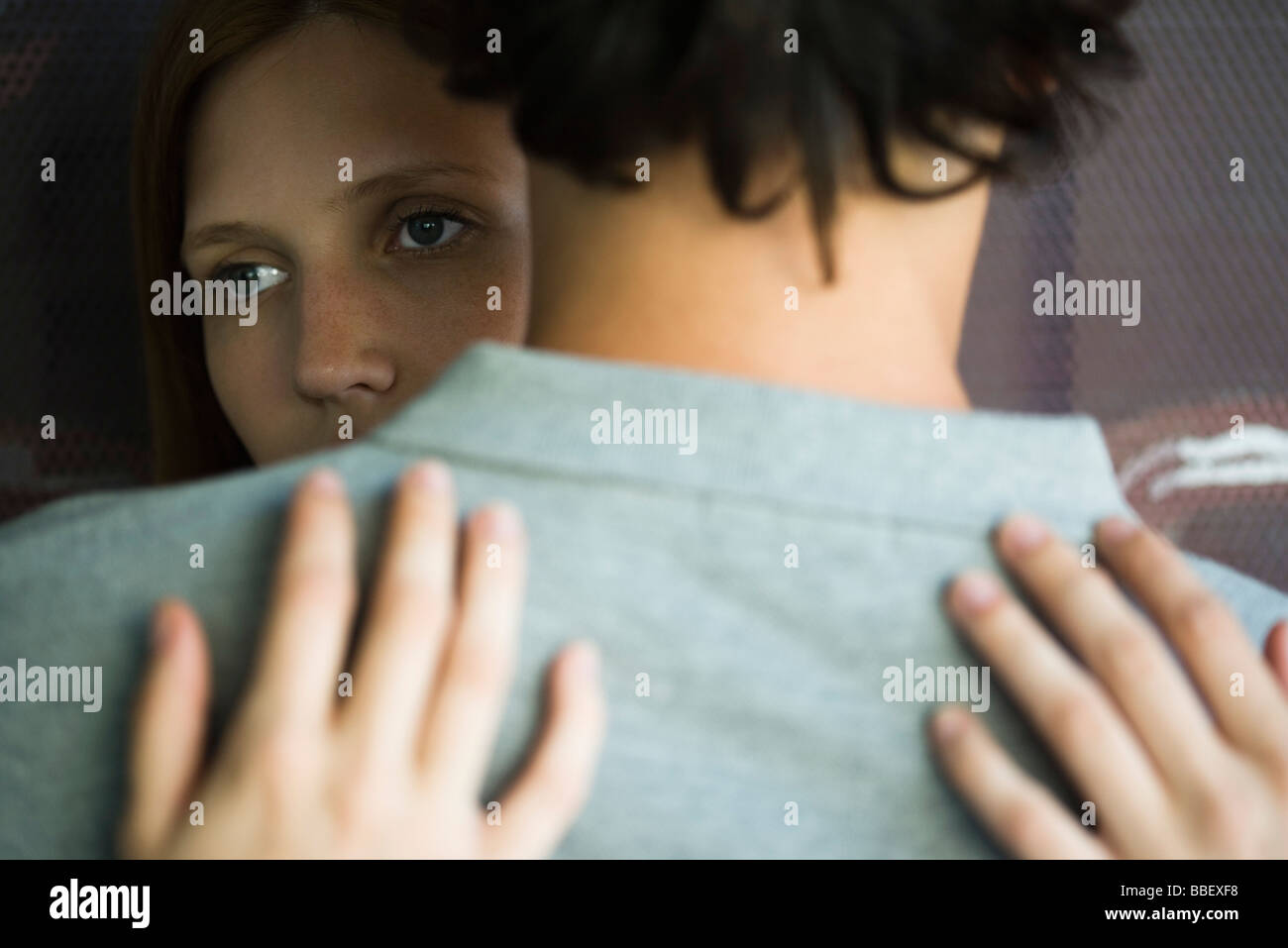 Young couple embracing, woman looking away Stock Photo