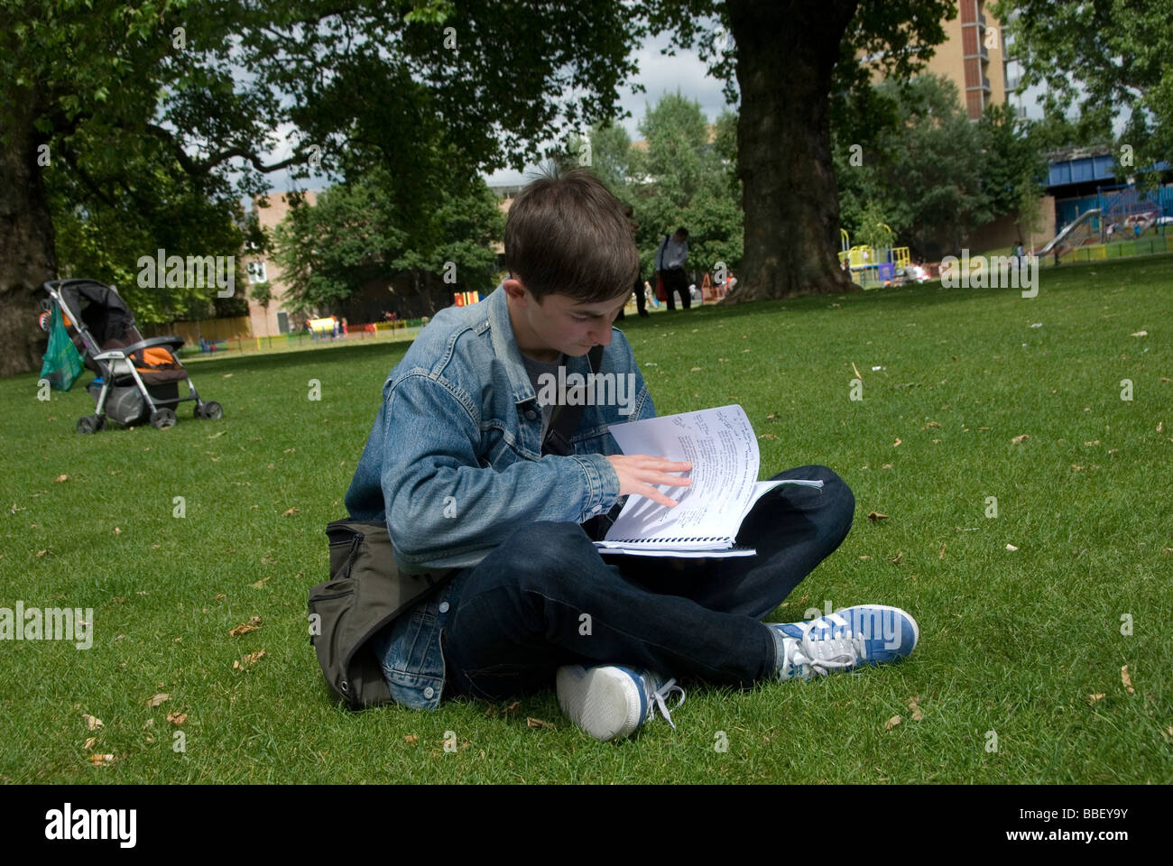 Teenage boy revising for A level exams in the park Stock Photo