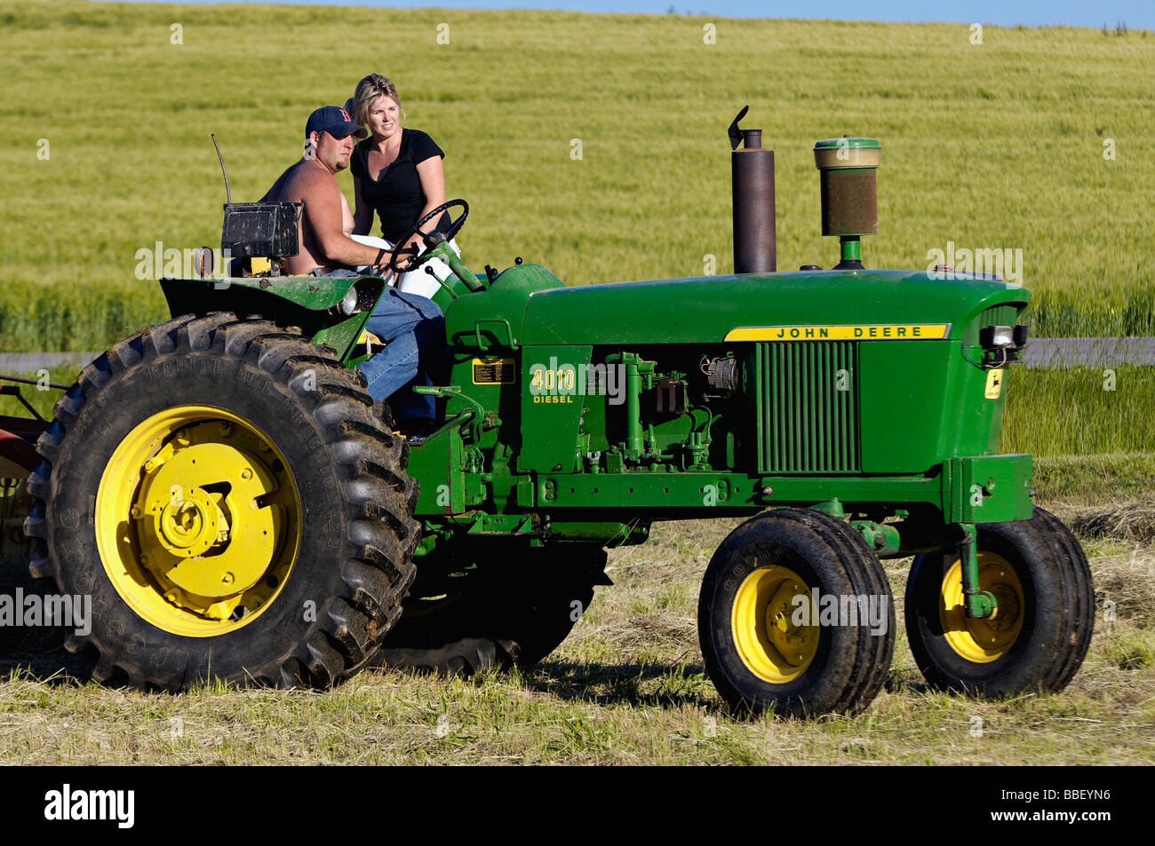 Farmer and his Wife on John Deere 3010 Diesel Tractor in Harrison Stock