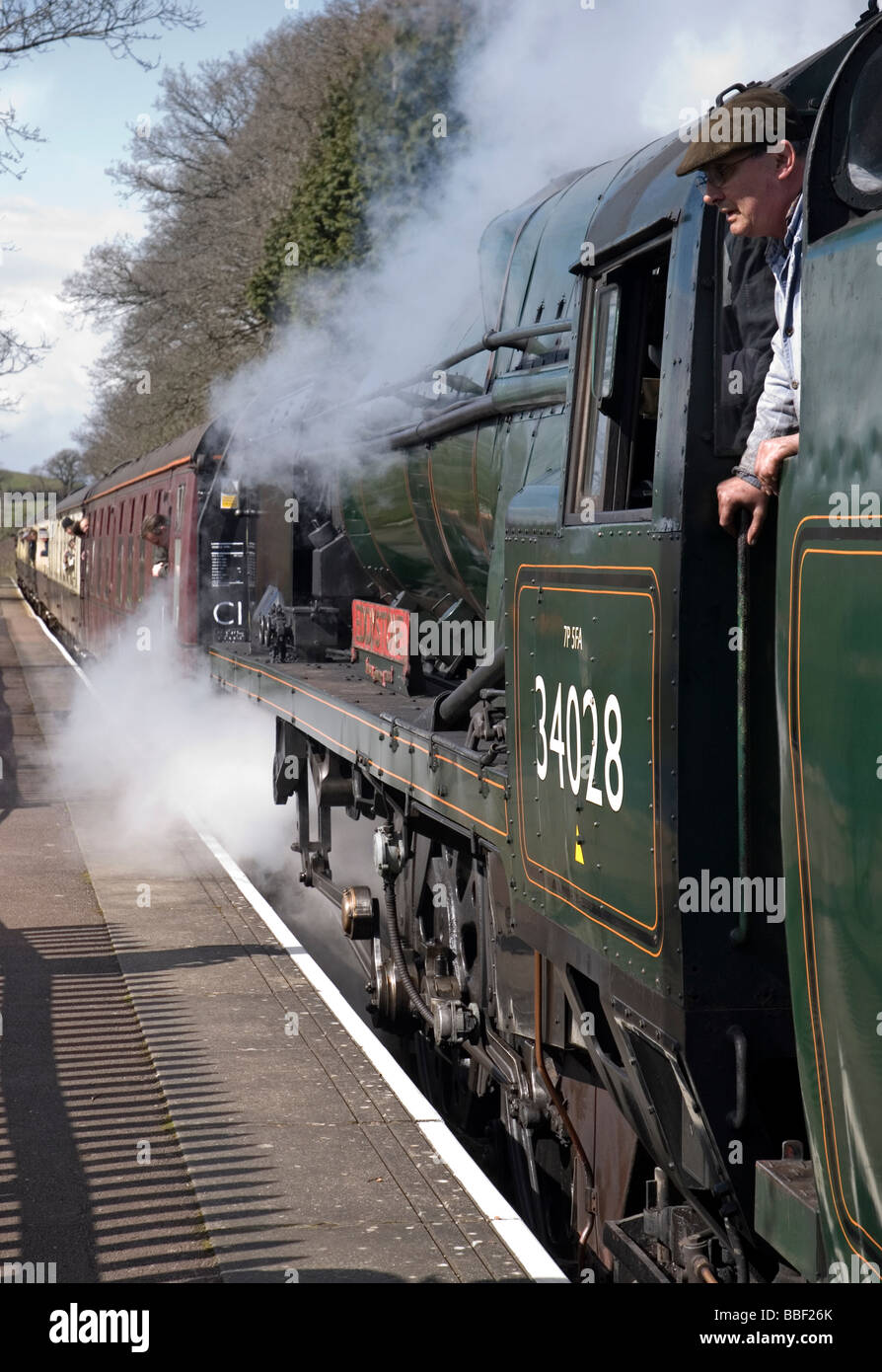 Steam train leaving a raiway station on the West Somerset Railway. Stock Photo