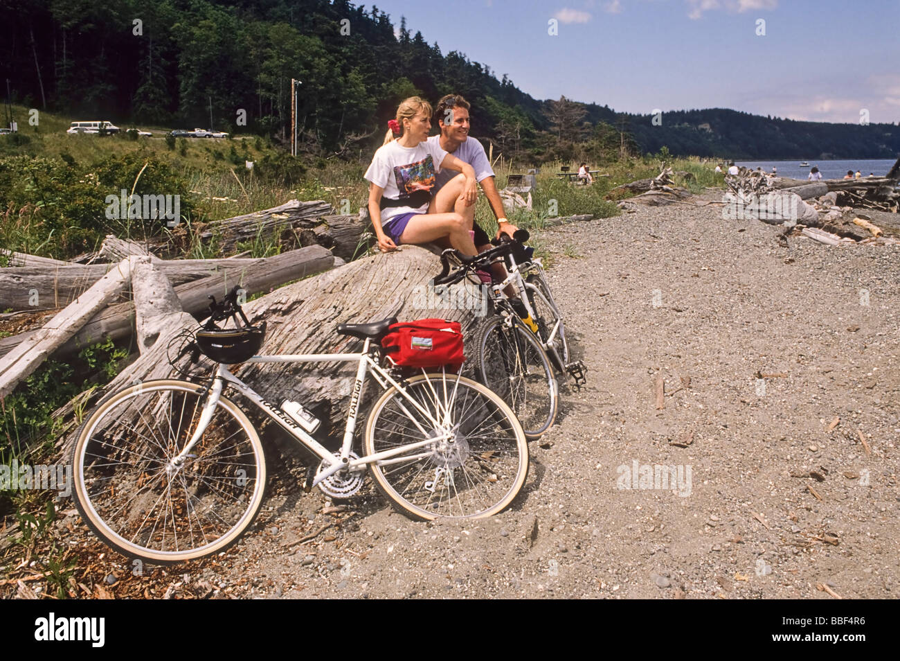 Man and woman bicycle riders take a break at Possession Point Whidbey Island WA USA Stock Photo